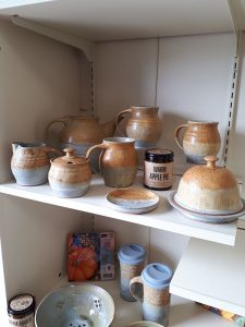 a shelf displaying a variety of pottery vessels