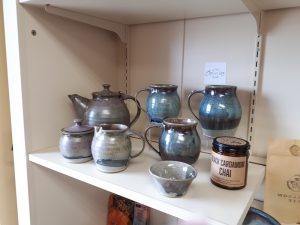 A shelf displaying various pottery vessels by Amanda Millar